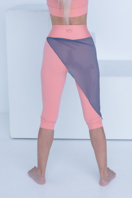 Person wearing a pink and gray athletic outfit on a white background