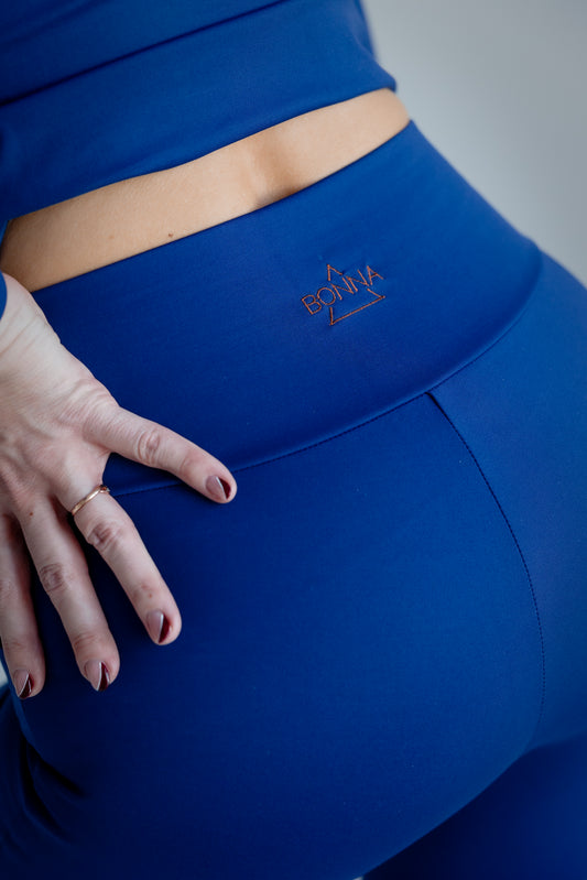 Blue leggings with a brand logo on a plain background