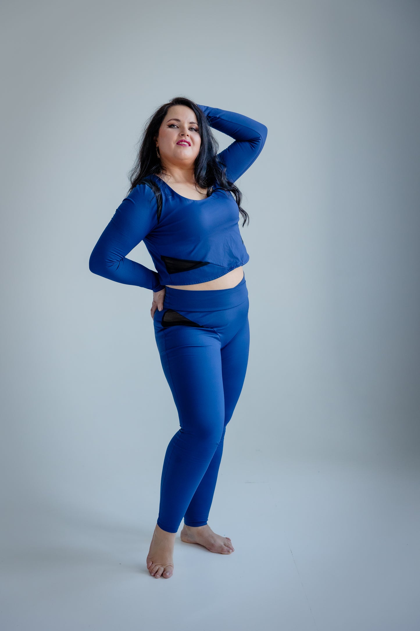 Woman wearing a blue athletic outfit on a gray background